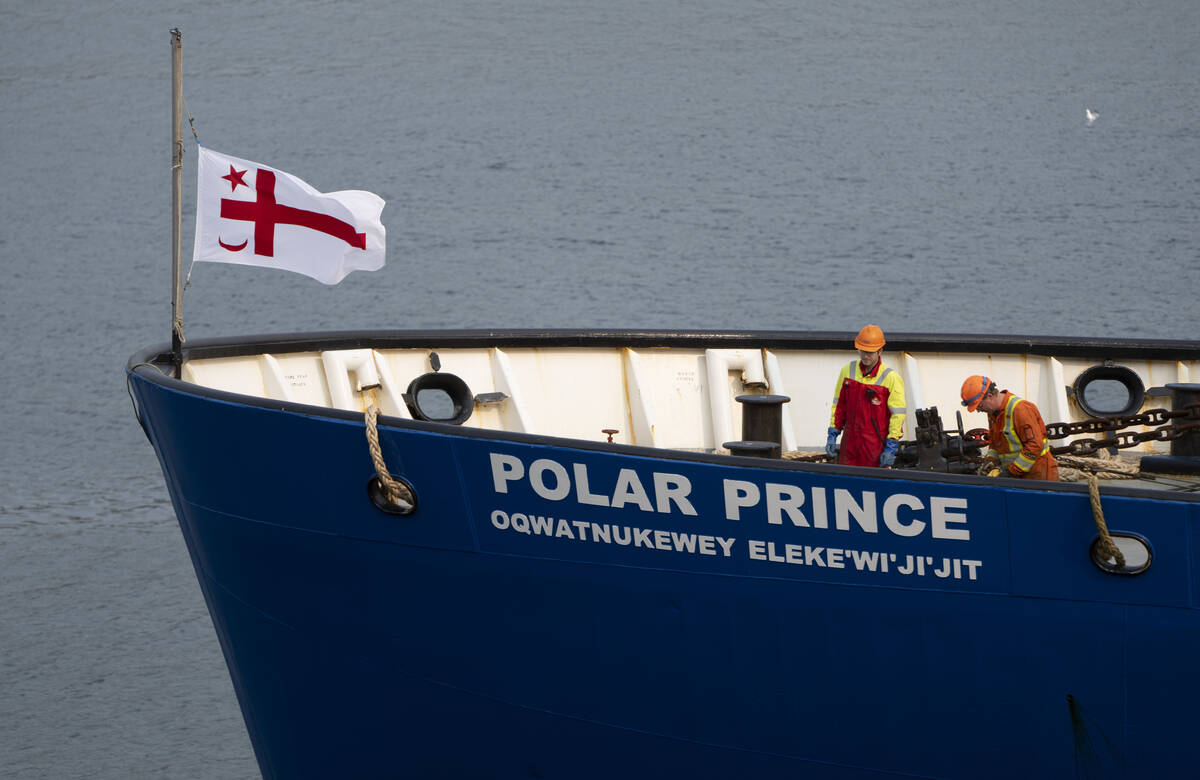 Crew members of the Polar Prince prepare to dock the ship as it arrives at the Coast Guard whar ...
