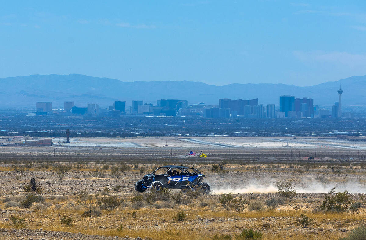 A buggy cruises across the desert within the Nellis Dunes as hot weather moving into the valley ...