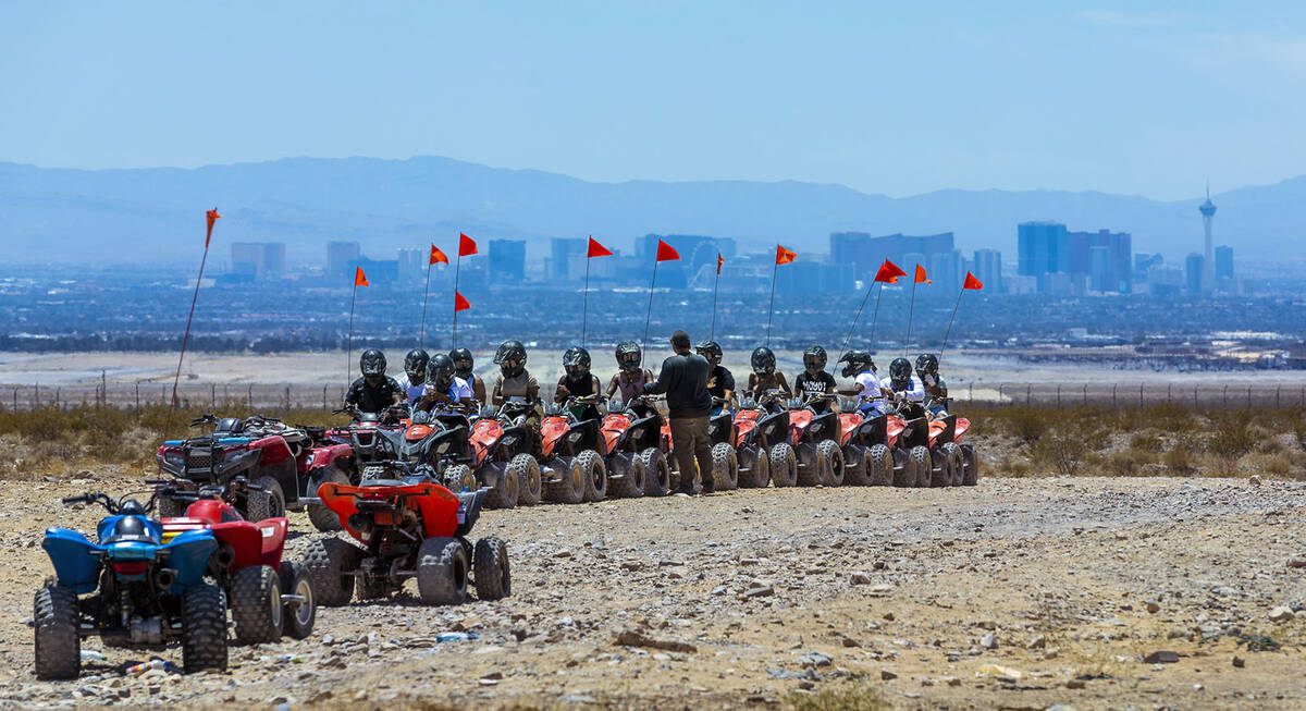 ATV riders receive instructions before a ride within the Nellis Dunes as hot weather moving int ...