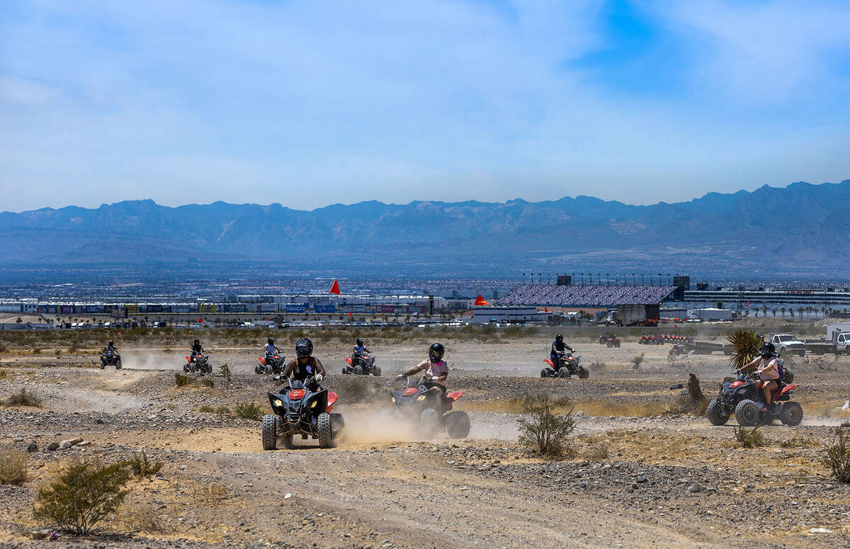 ATV riders take a ride within the Nellis Dunes as hot weather moving into the valley on Saturda ...