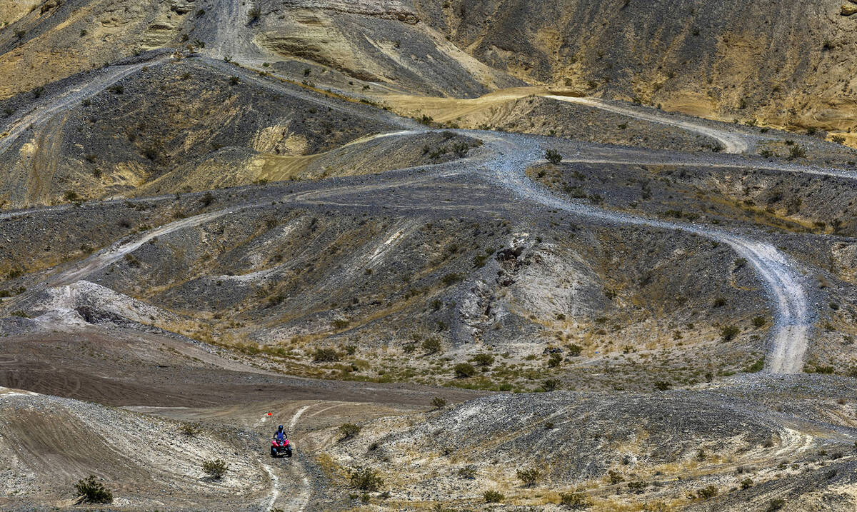 An ATV rider navigates a road within the Nellis Dunes as hot weather moving into the valley on ...