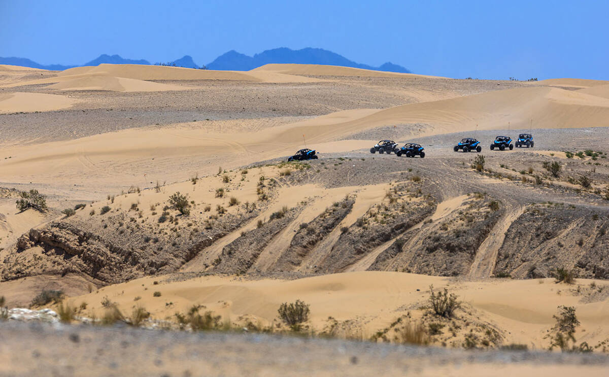 Buggies descend from to the top of a rise within the Nellis Dunes as hot weather moving into th ...