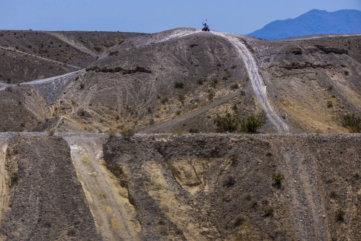 An ATV rider gets to the top of a rise within the Nellis Dunes as hot weather moving into the v ...