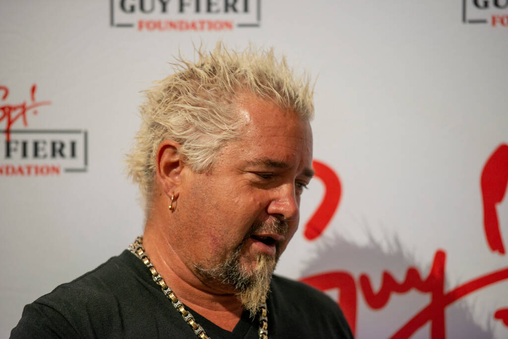 Chef and TV personality Guy Fieri talks to the media during an event honoring veterans and firs ...