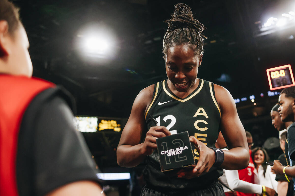 Las Vegas Aces guard Chelsea Gray signs a bobblehead of herself for a fan after beating the Ind ...