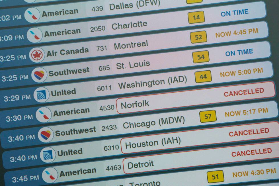 A monitor displays in the departures area of Terminal B at LaGuardia Airport displays flight st ...
