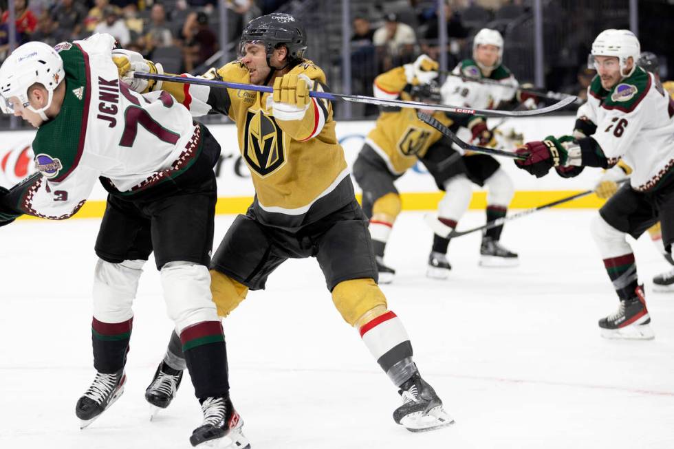 Golden Knights defenseman Jake Bischoff (45) collides with Coyotes forward Jan Jenik (73) durin ...