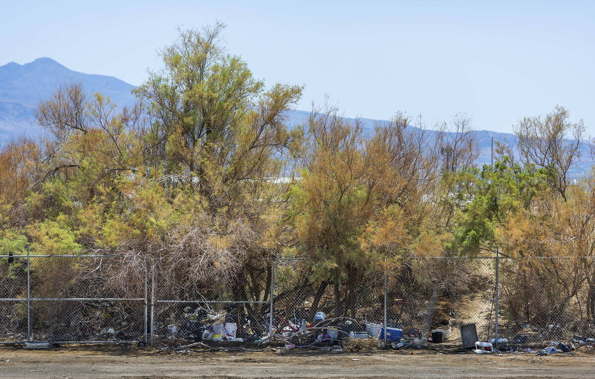 Discarded items line the fence line near a brush fire adjacent to the Las Vegas Wash along the ...