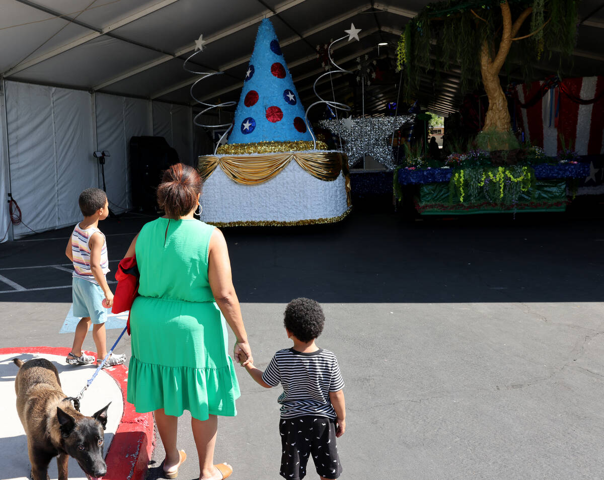 Jennifer Montgomery and her sons, Devyn, 5, right, Myles, 2, and her dog Zuma check out floats ...