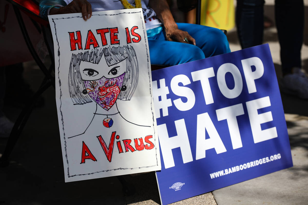Rozita Lee holds signs at a “Stop Asian Hate” rally outside the Regional Justice Center in ...