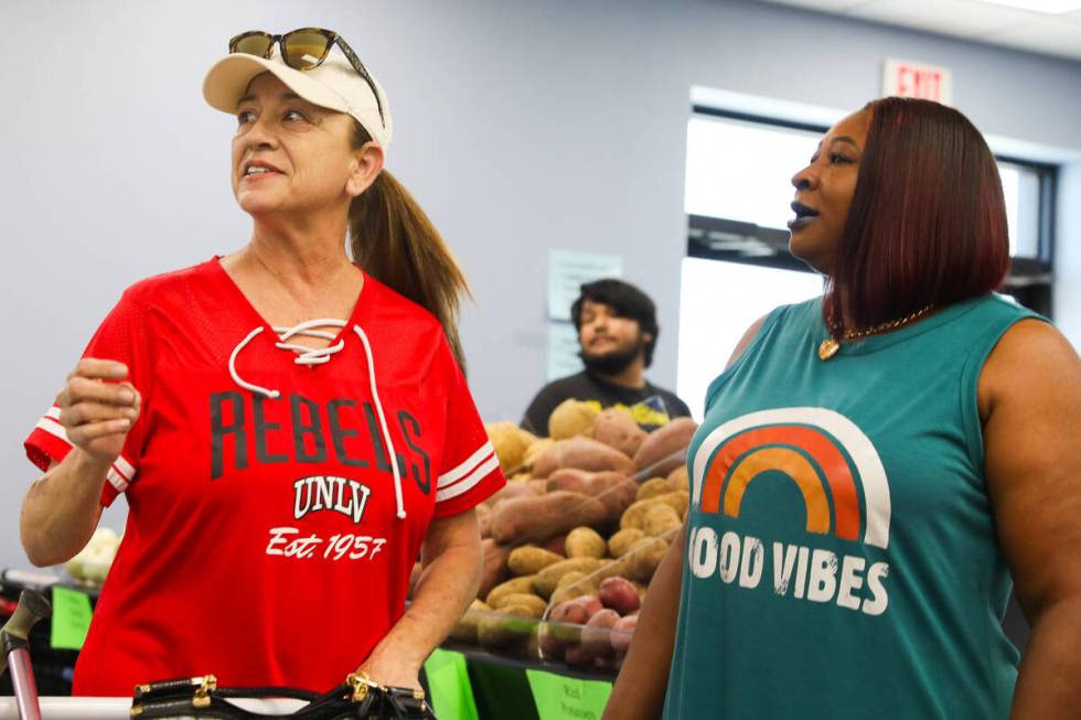 Adrian McCoy, right, greets Isabella Smith as she is shopping for groceries at The After Market ...