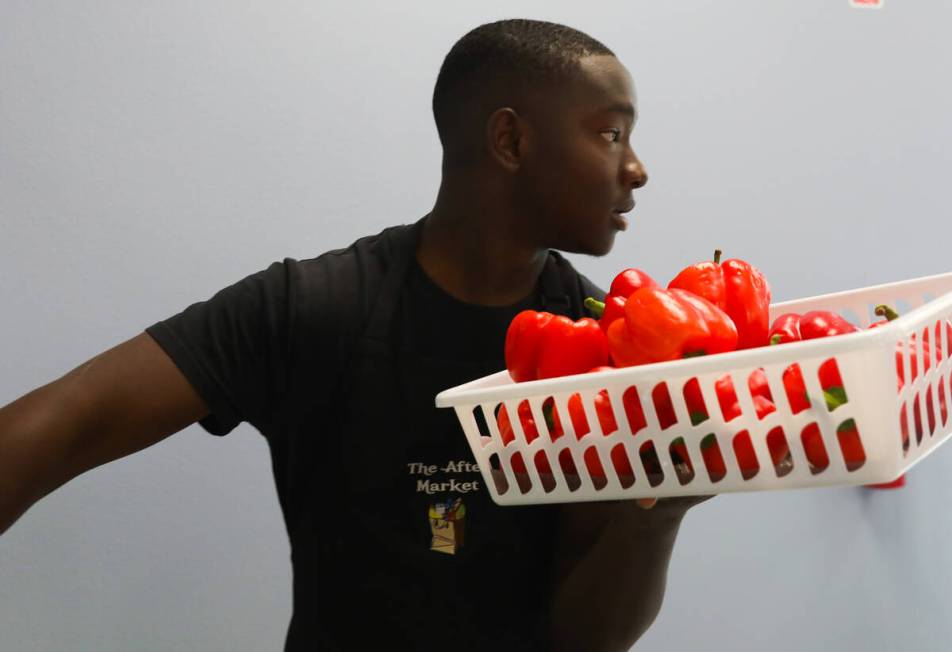 DeWayne Jr. McCoy restocks fresh vegetables at The After Market on Thursday, June 22, 2023, in ...