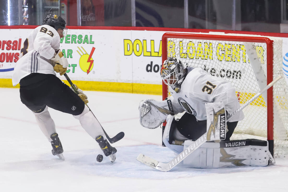 Golden Knights goaltender Isaiah Saville defends the net as forward Daniel D’Amato looks ...