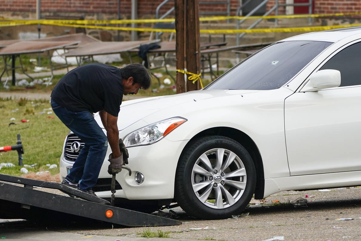 A tow truck operator removes a vehicle with multiple bullet holes near the area of a mass shoot ...