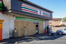 Workers board up the 7-Eleven on Boulder Highway and South Lamb Boulevard where a person was ki ...