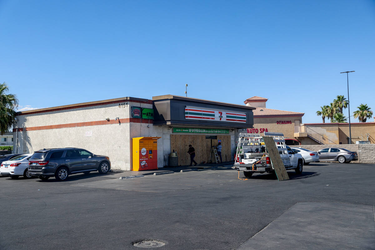 Workers board up the 7-Eleven on Boulder Highway and South Lamb Boulevard where a person was ki ...