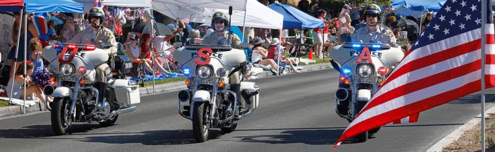 Police officers ride bikes during the annual Summerlin Council Patriotic Parade, Tuesday, July ...