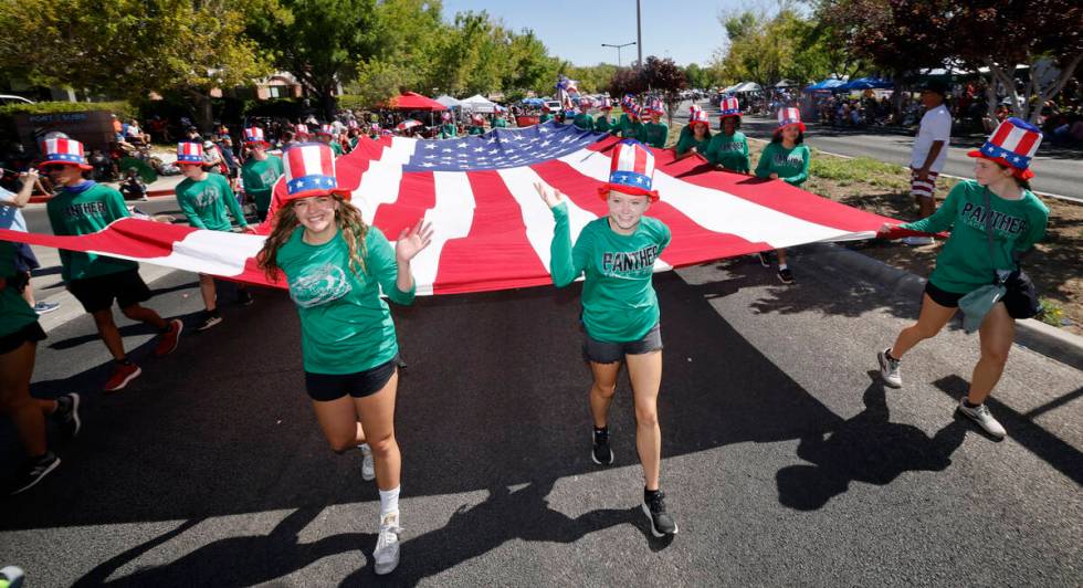 Children carry a large American flag during the annual Summerlin Council Patriotic Parade, Tues ...