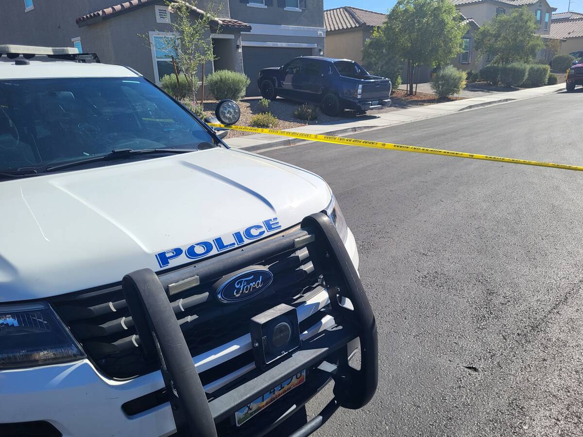 A North Las Vegas police vehicle is seen next to police tape cordoning off a crime scene at a h ...