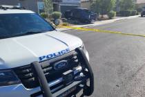 A North Las Vegas police vehicle is seen next to police tape cordoning off a crime scene at a h ...