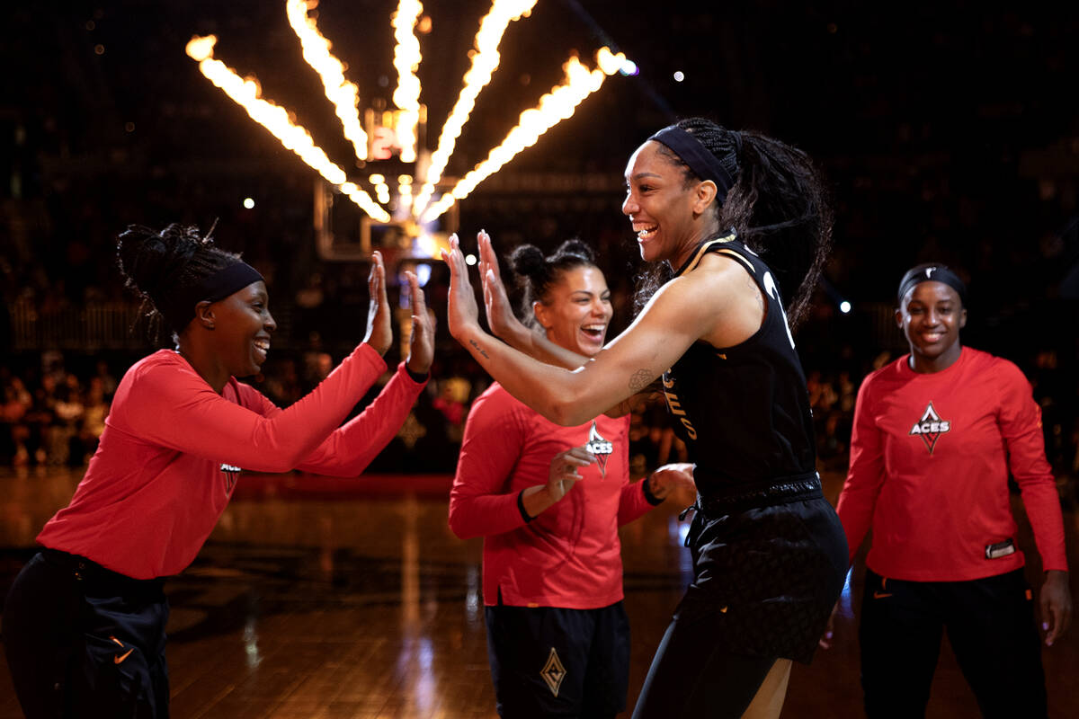 Las Vegas Aces forward A'ja Wilson, center right, slaps hands with guard Chelsea Gray, left, as ...