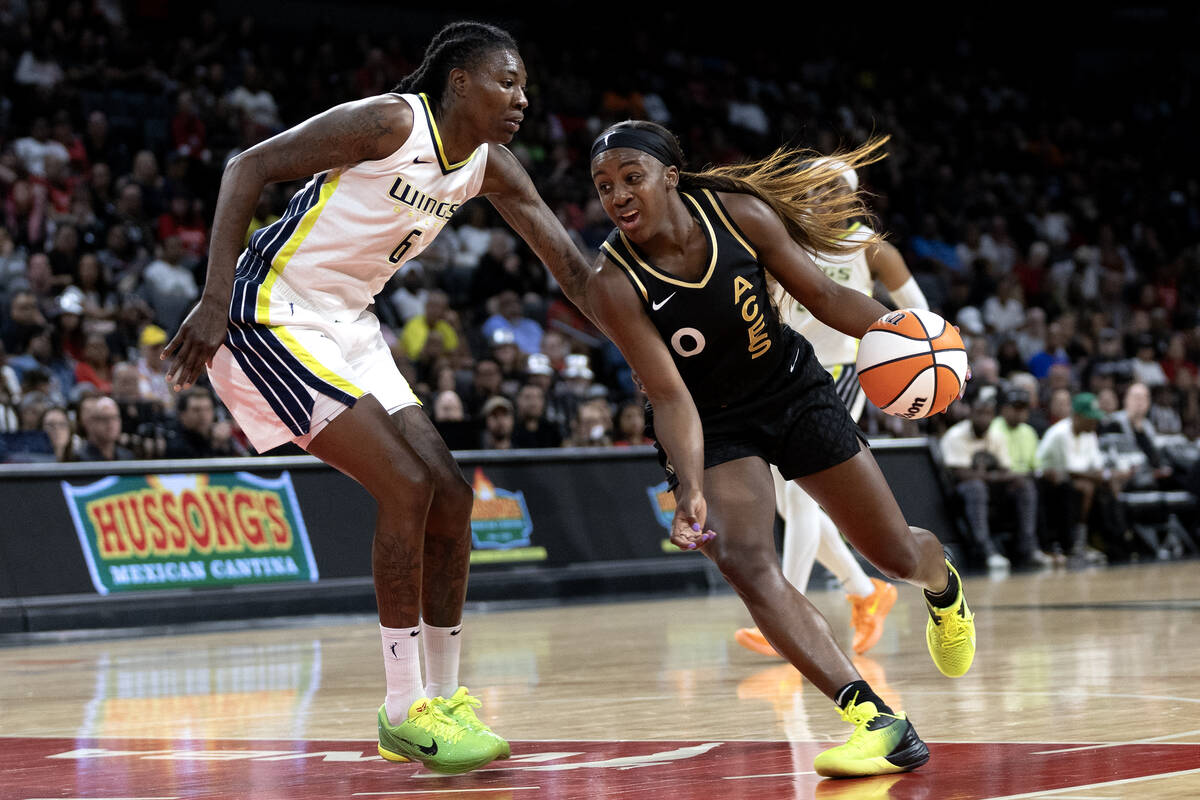 Las Vegas Aces guard Jackie Young (0) drives around Dallas Wings forward Natasha Howard (6) dur ...