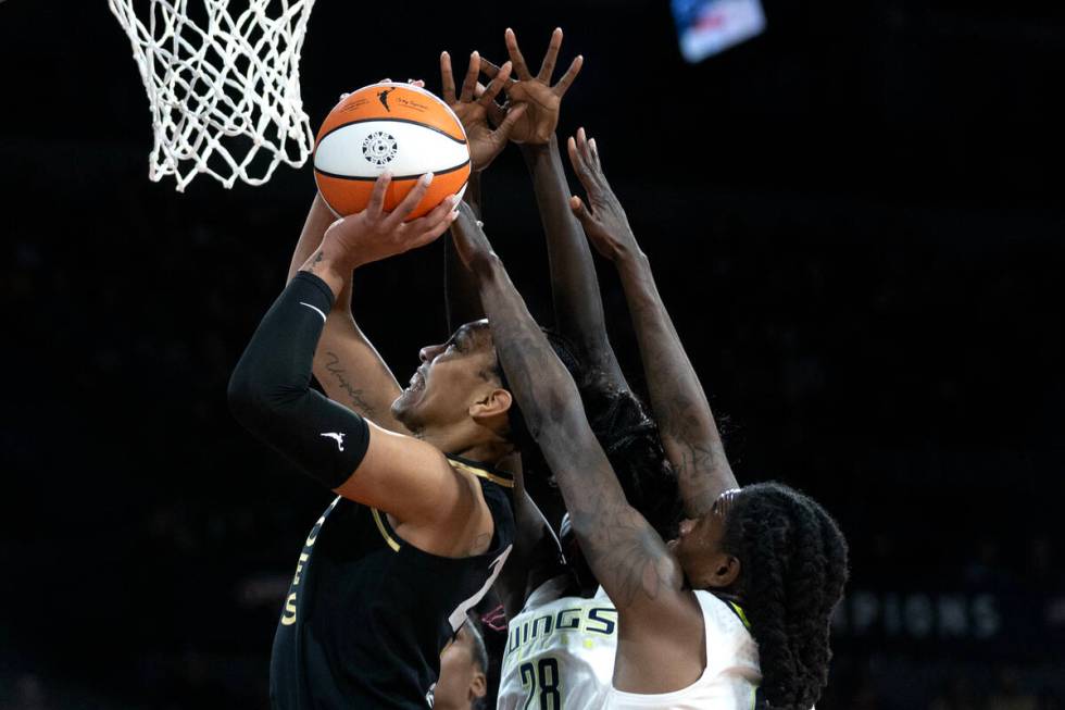 Las Vegas Aces forward A'ja Wilson (22) shoots against Dallas Wings center Awak Kuier (28) and ...