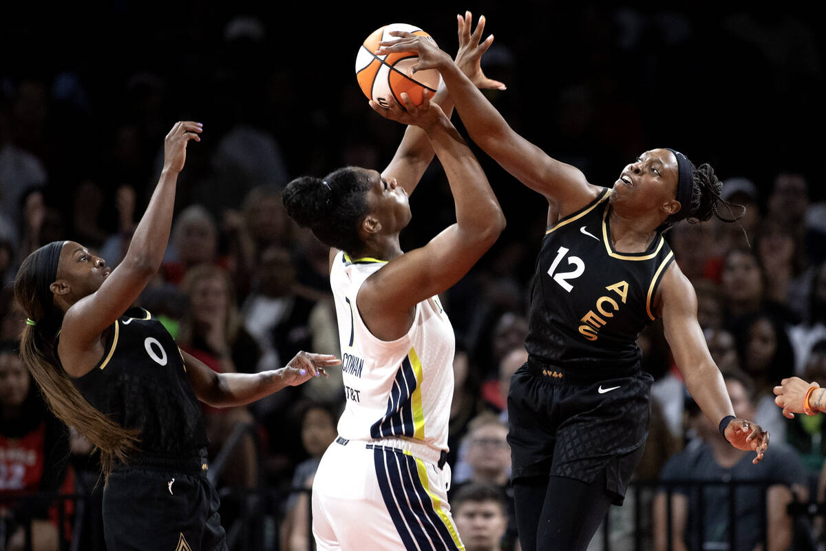 Las Vegas Aces guard Chelsea Gray (12) blocks a shot by Dallas Wings center Teaira McCowan (7) ...