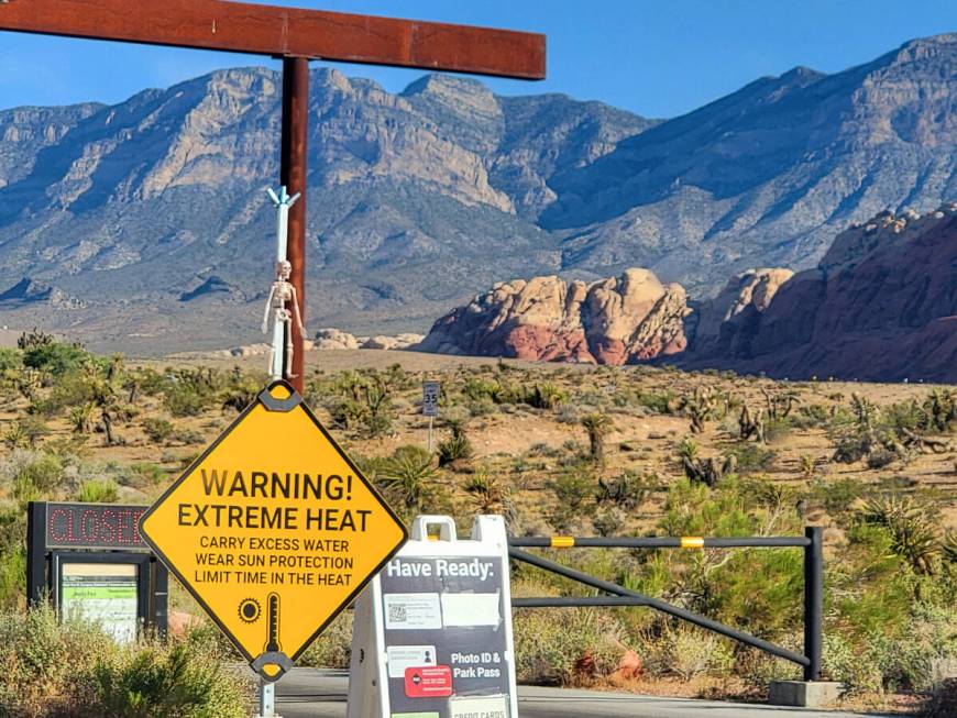 A summer sign decorated with a skeleton warns of extreme heat at the visitor gate for the popul ...