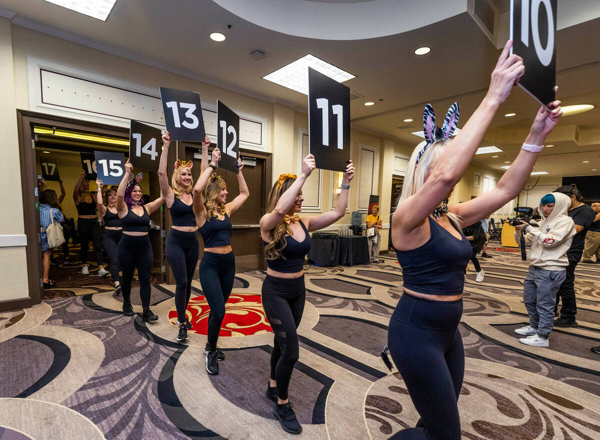 Models enter and hold numbers representing Phil Hellmuth's 17 gold bracelets as the “The ...