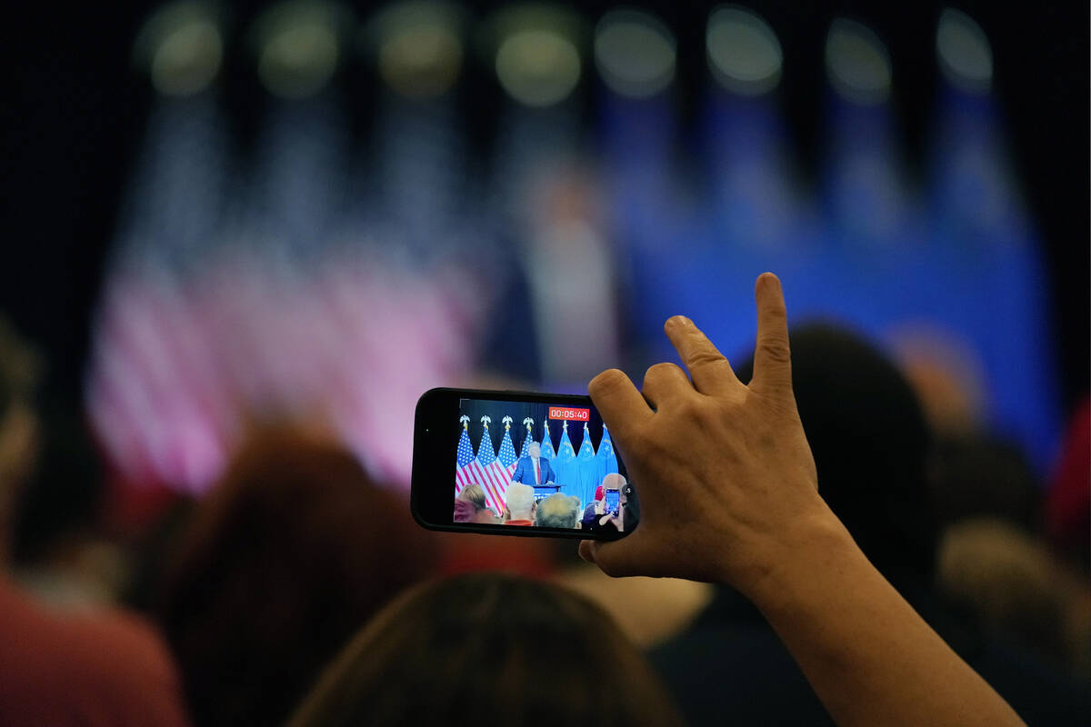 A person records video as former President Donald Trump speaks at a campaign event, Saturday, J ...