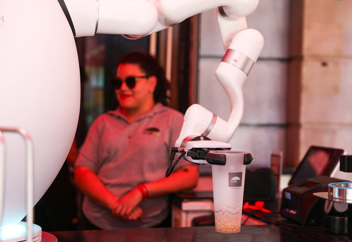 Paola Valdez sits back and relaxes as Adam the robot prepares drinks at Cloutea, the first boba ...