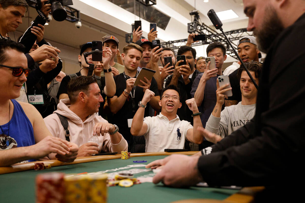 Thanh Nguyen, third from left, reacts after he was not eliminated during World Series of Poker ...