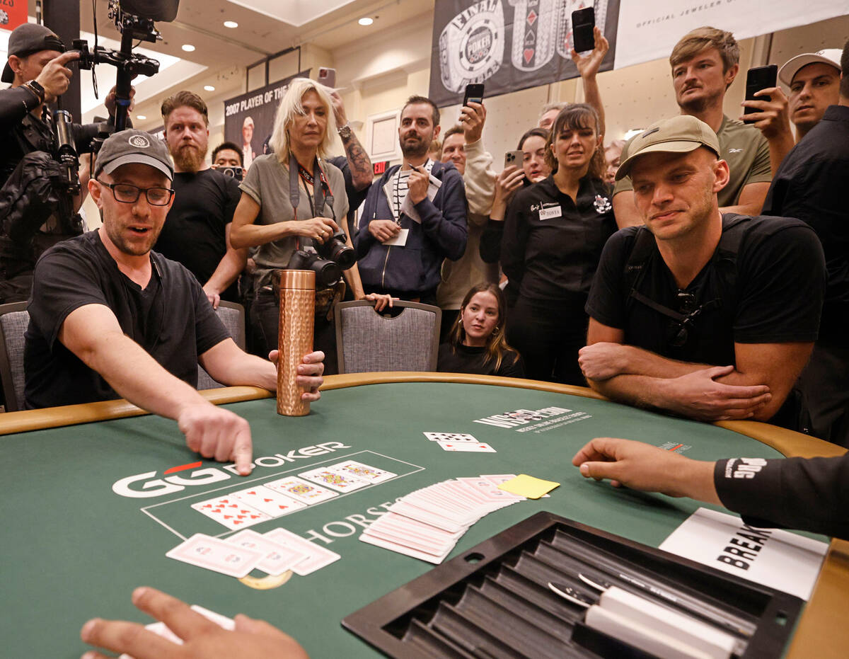 Peter Nigh of USA and Jeppe Bisgaard of Denmark look at cards to win a free seat to the Main E ...
