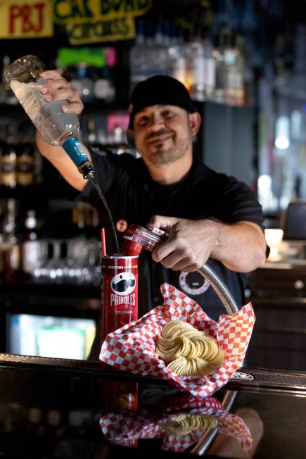 Bartender Mean Gene pours “The Fletcher,” a rum and coke served in a Pringles can ...