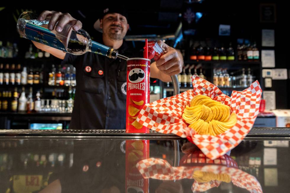 Bartender Mean Gene pours “The Fletcher,” a rum and coke served in a Pringles can ...