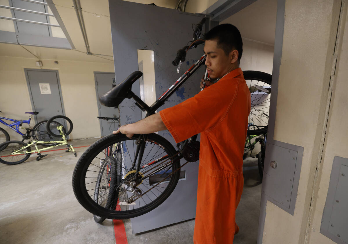 Inmate Alfredo Custodio carries a bike from a storage room to repair at North Las Vegas Communi ...