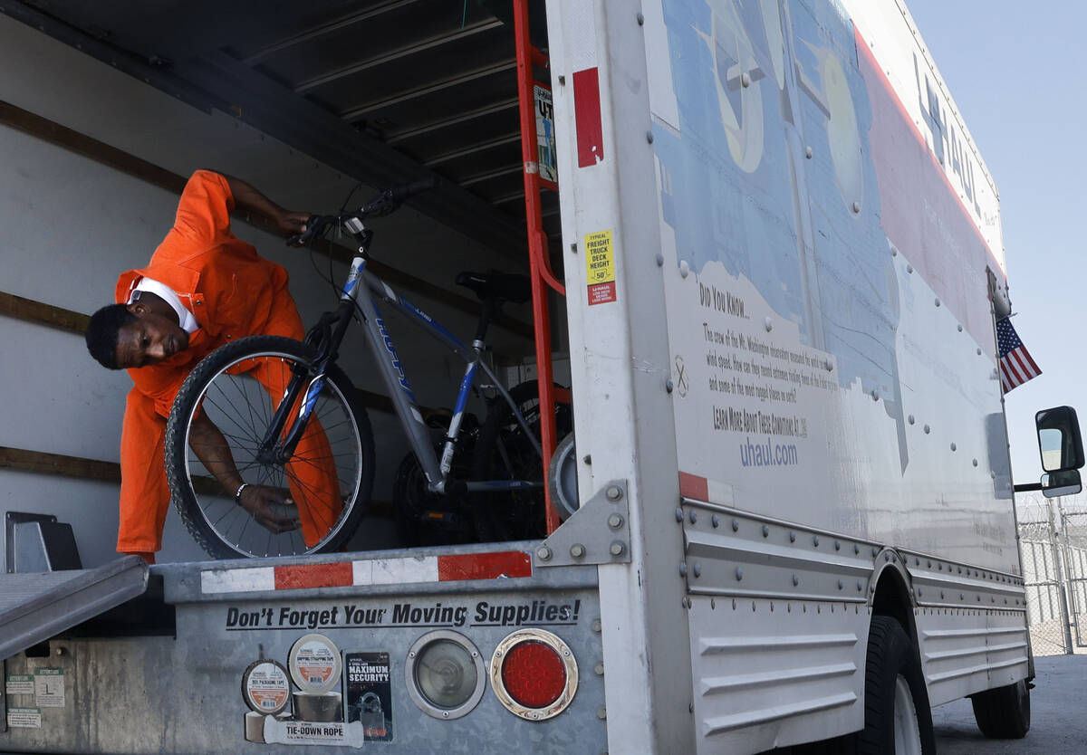 Inmate Ryan Brandon checks a bike as he unloads bikes from a truck at North Las Vegas Community ...