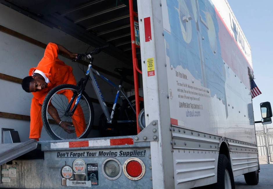 Inmate Ryan Brandon checks a bike as he unloads bikes from a truck at North Las Vegas Community ...