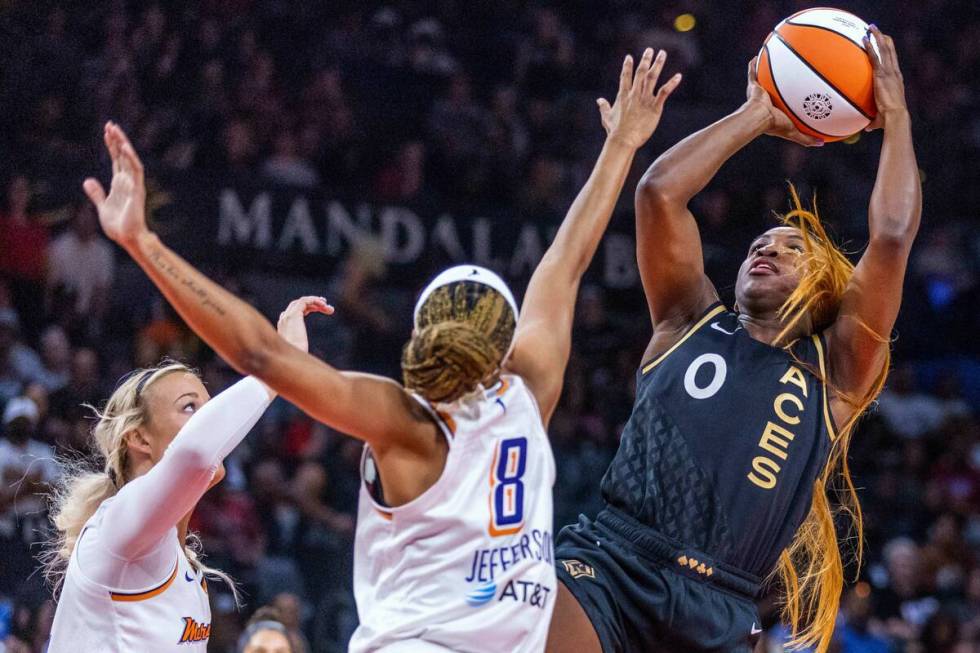 Las Vegas Aces guard Jackie Young (0) leans back for a shot over Phoenix Mercury guard Moriah J ...