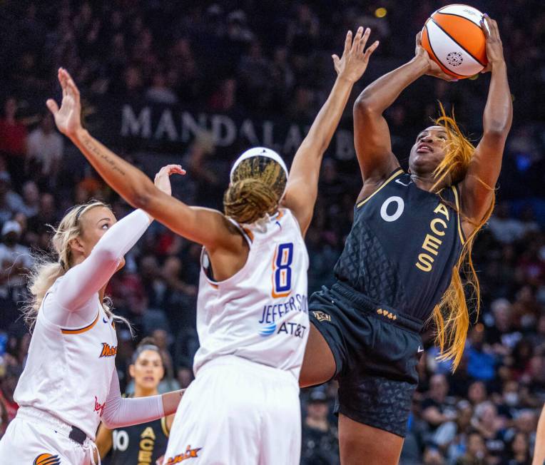 Las Vegas Aces guard Jackie Young (0) leans back for a shot over Phoenix Mercury guard Moriah J ...