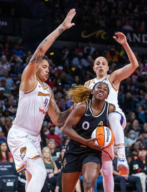 Las Vegas Aces guard Jackie Young (0) drives to the basket between Phoenix Mercury center Britt ...