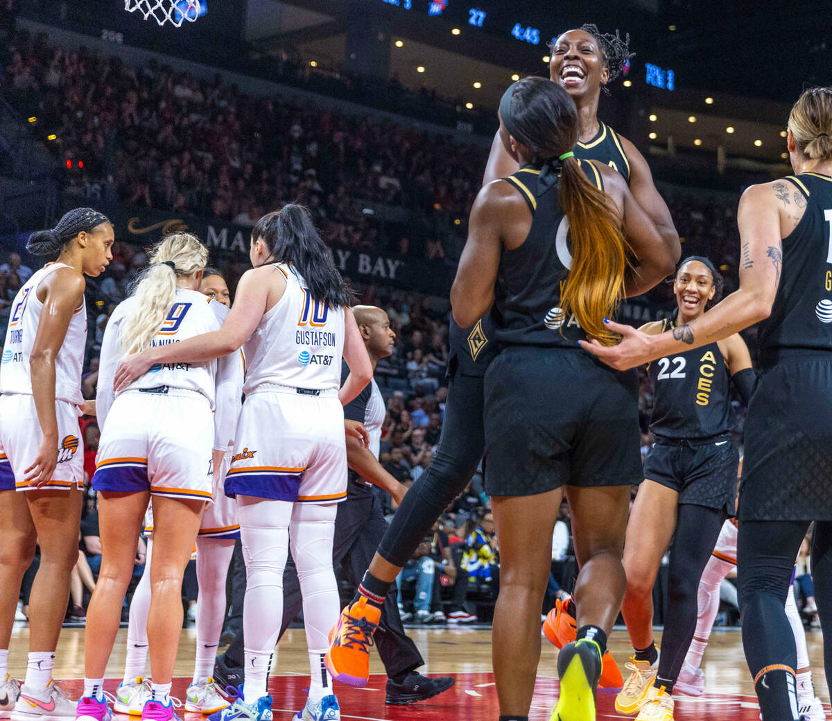 Aces guard Chelsea Gray (12) leaps into the arms of guard Jackie Young (0) as the team celebrat ...