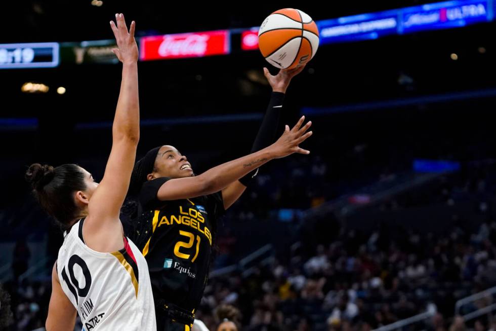 Los Angeles Sparks guard Jordin Canada (21) lays the ball up past Las Vegas Aces guard Kelsey P ...