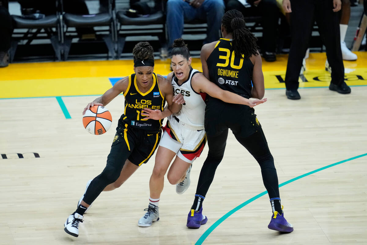 Las Vegas Aces guard Kelsey Plum, center, defends against Los Angeles Sparks guard Jasmine Thom ...