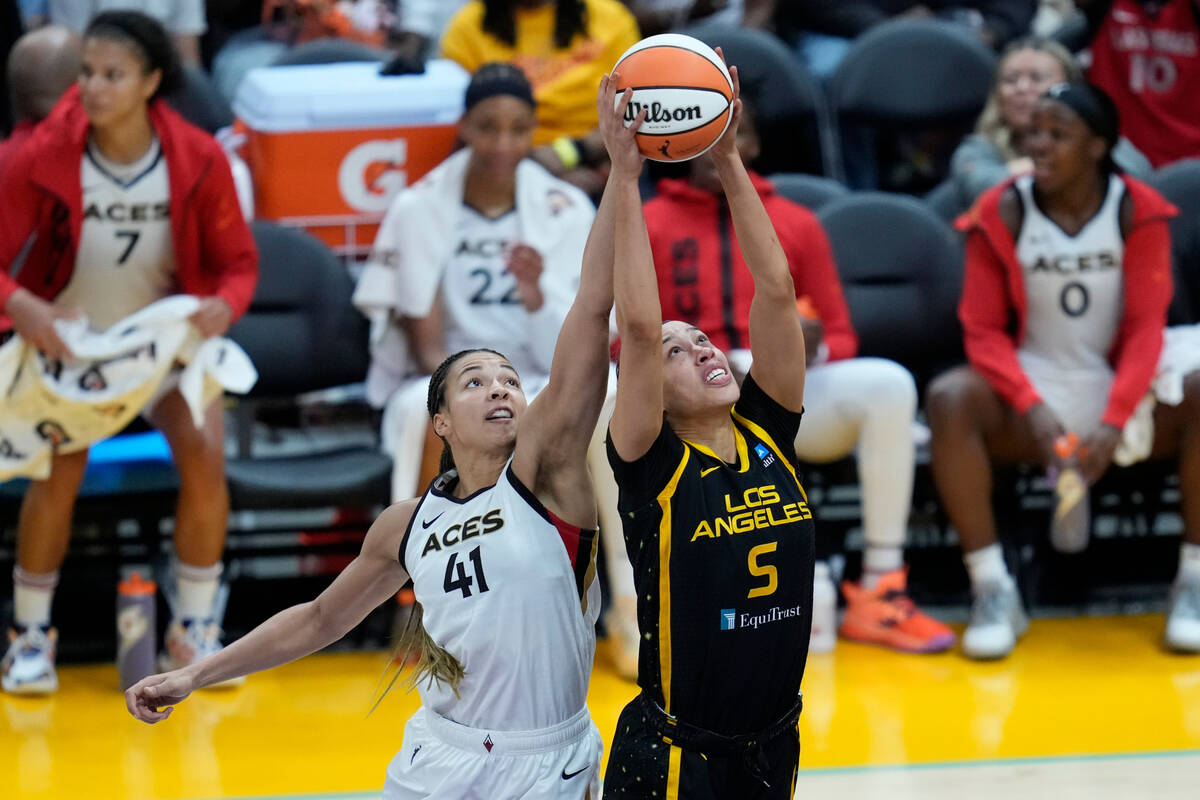 Las Vegas Aces center Kiah Stokes (41) and Los Angeles Sparks forward Dearica Hamby (5) reach f ...