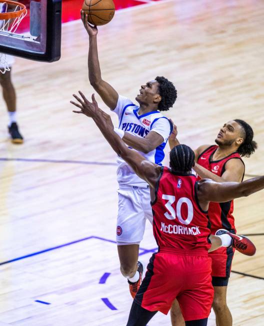 Detroit Pistons guard Jared Rhoden (8) elevates for a basket over Toronto Raptors center David ...