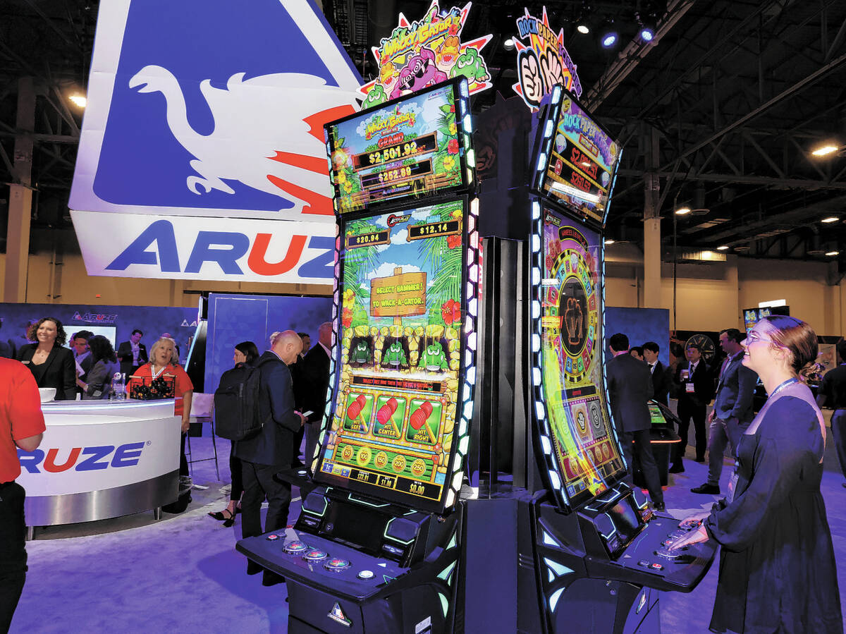 Cailey Henderson plays the Rock Paper Scissors slot game in the Aruze Gaming America booth at t ...