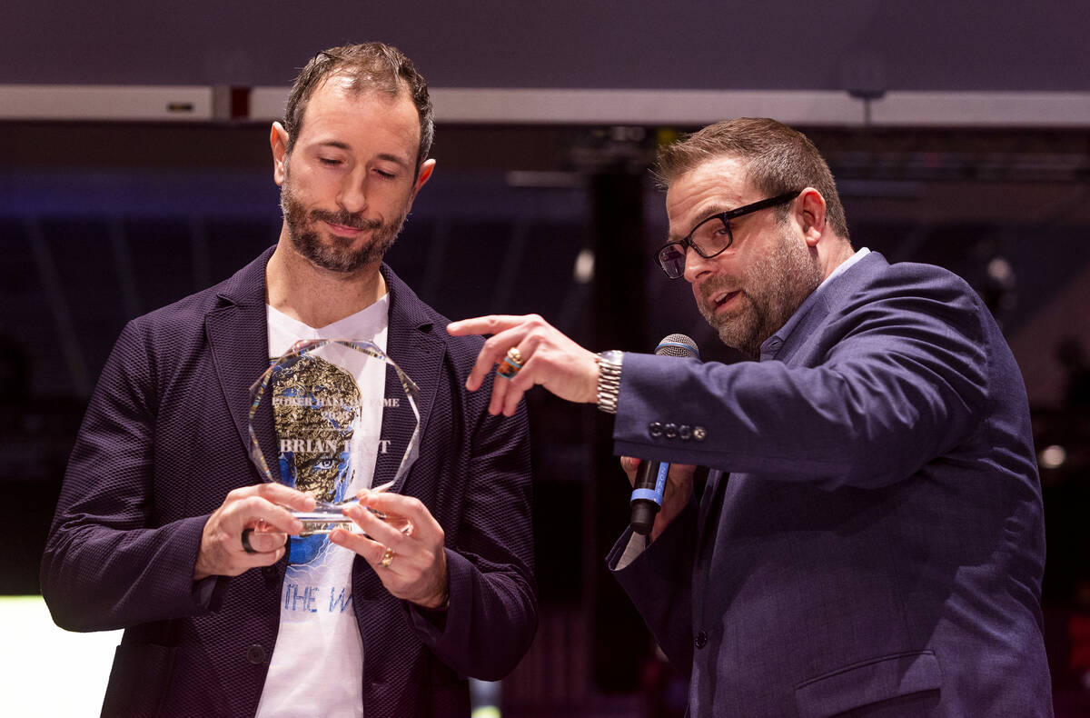 Brian Rast receives a trophy from World Series of Poker vice presdient Jack Effel as the 2023 H ...