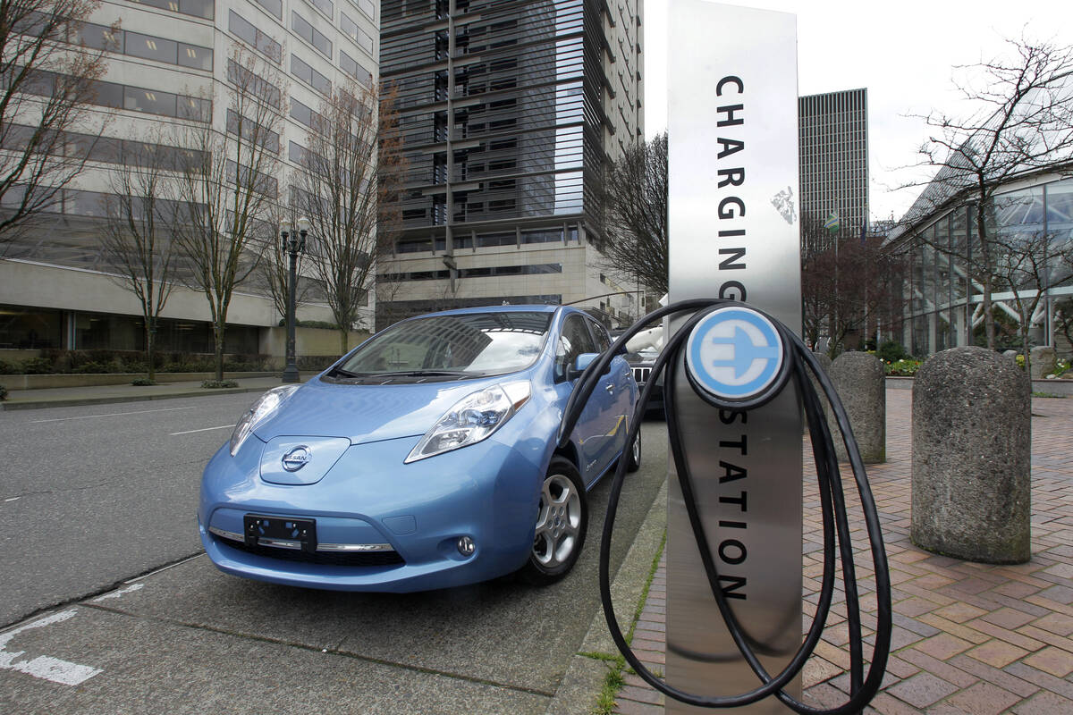 FILE - A car is parked by an electric charging station in downtown Portland, Ore., March 31, 20 ...